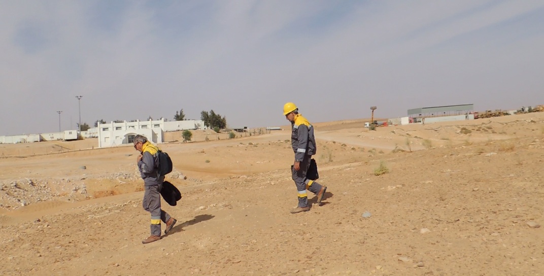 Two geologists walking desert rig site